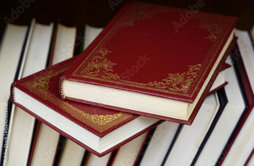 Foto Two red hardcover books on the top of the other books on the book shelf