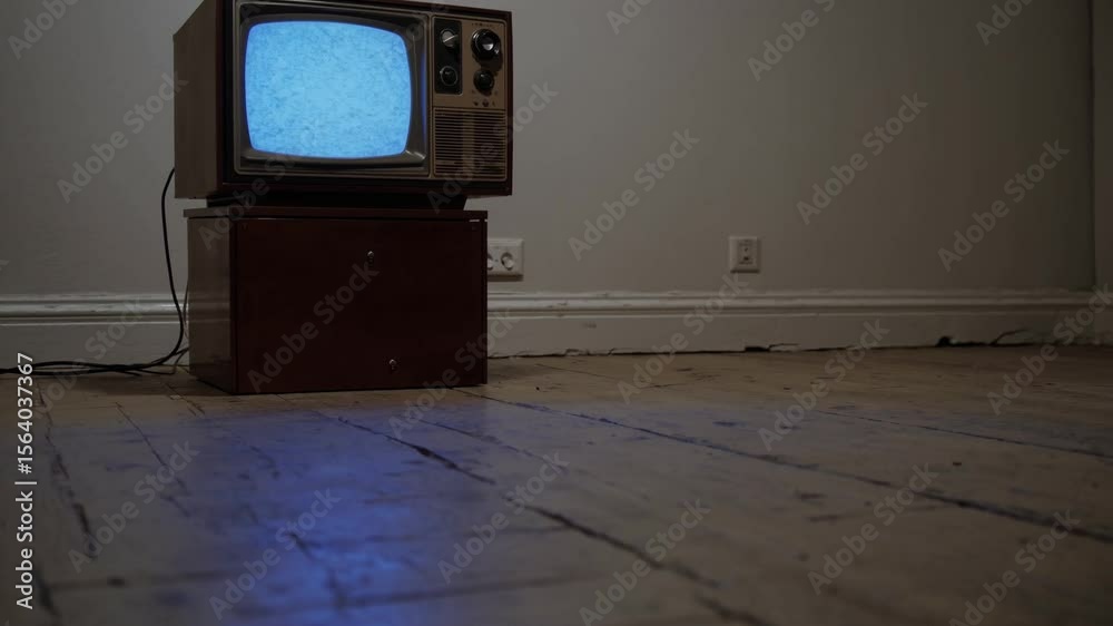 Télévision vintage allumée dans une pièce vide