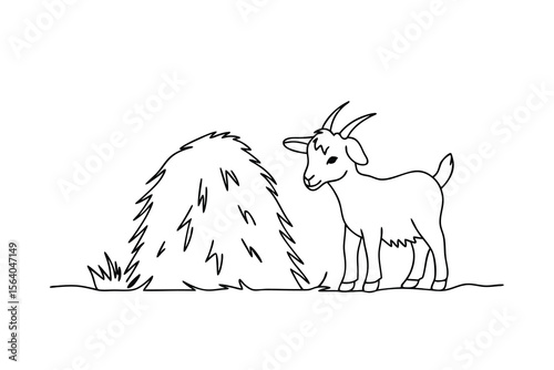 Young goat standing near hay bale animal farm