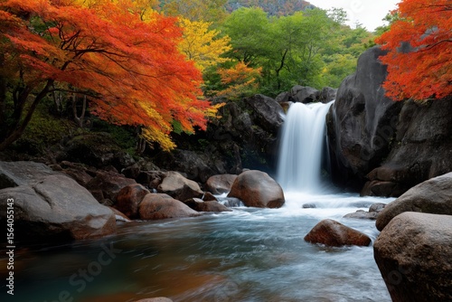 Serene autumn waterfall surrounded by vibrant foliage in forest scenery