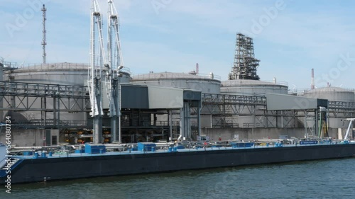 Antwerp, Belgium - June 20, 2025: Storage tanks,  refinery and ships in the port of Antwerp, Belgium