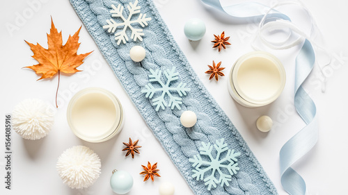 A flat lay winter-themed composition on a white background with a light blue knitted fabric strip in the center.