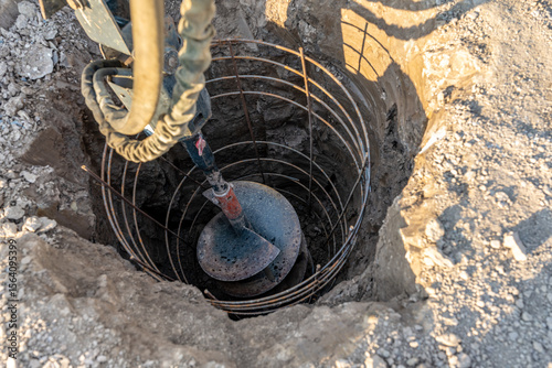 Construction equipment drilling vertical hole for a cast in place reinforced concrete pile foundation
