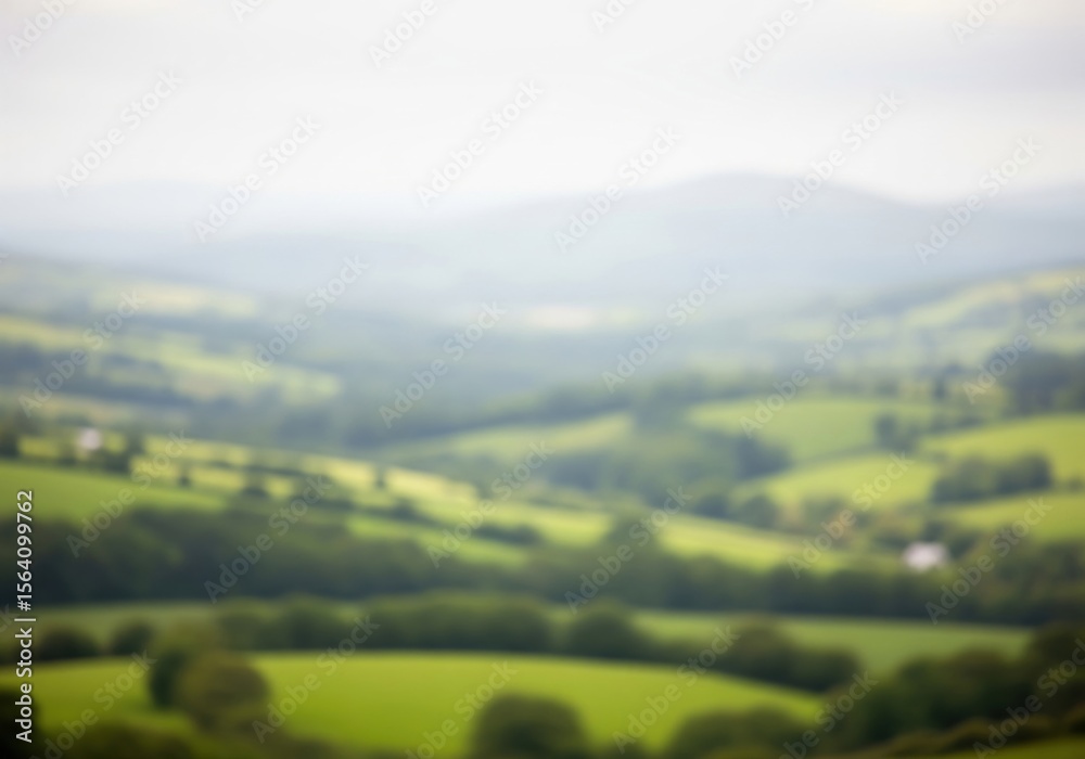 Obraz premium Blurred Verdant Countryside View. This soft focus natural vista of rolling hills and distant peaks creates a serene, dreamlike ambiance. Perfect for backgrounds and calm themes.