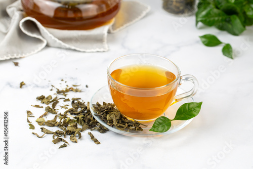 Cup of healthy green tea with tea leaves.