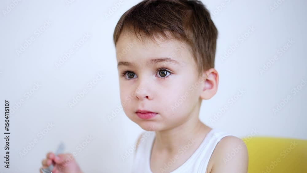 Boy snacking healthily at home. A young boy seated at a table happily eating a snack. Bright colors and simple decor surround him in a cozy setting. Boy snacking healthily at home. A young boy seated at a table happily eating a snack. Bright colors and simple decor surround him in a cozy setting.