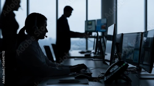 Wallpaper Mural silhouettes of focused call center agents working in modern office with multiple screens Torontodigital.ca