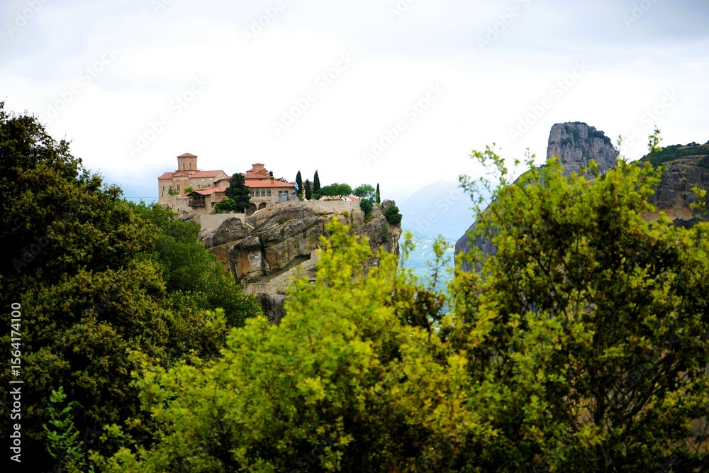 Obraz premium Varlaam Monastery perched on towering sandstone cliffs in Meteora, Greece. Historic Eastern Orthodox monastery.