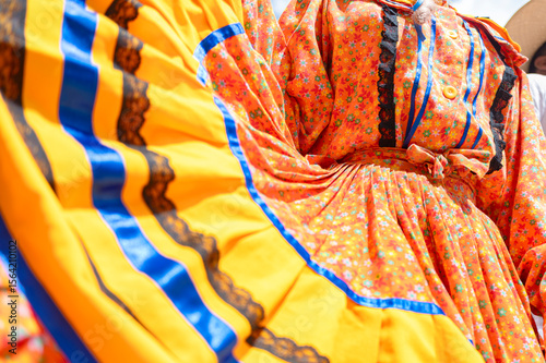 Close-up of colombian dancer wearing traditional colorful dress is performing