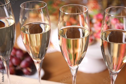 Fototapeta Naklejka Na Ścianę i Meble -  Buffet menu. Glasses of sparkling wine and tasty appetizers on table, closeup