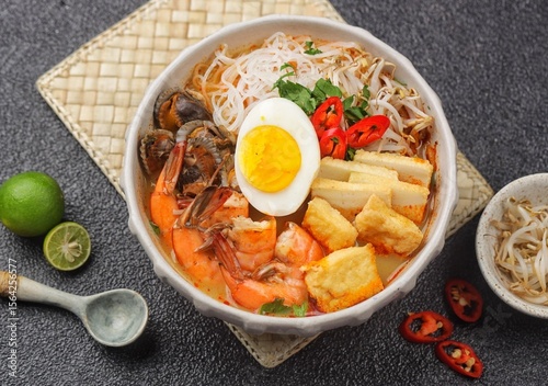 Laksa is a spicy noodle soup popular in the Peranakan cuisine of Southeast Asia. Laksa consists of thick wheat noodles or rice vermicelli with chicken, prawn or fish, served in spicy soup.