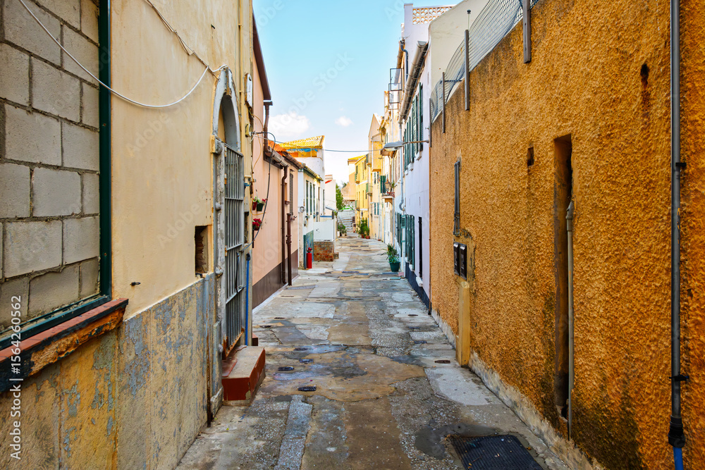 Obraz premium A narrow residential alley through the winding historic old town district under the Moorish Castle in Gibraltar, UK.