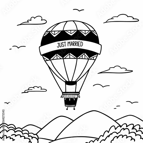 A hot air balloon with just married banner floats over mountains and clouds