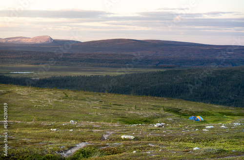 Two colorful camping tents set up in the serene morning light of the Dalarna mountains, surrounded by lush tundra and expansive plains. Wild camping in Idre Sweden, Städjan Nipfjället nature reserve