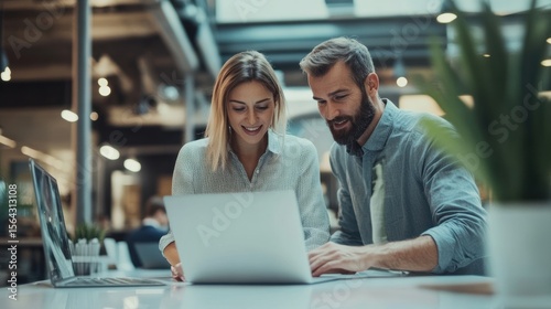 Collaborative Teamwork in Modern Office Setting: Professionals Working Together on Laptop