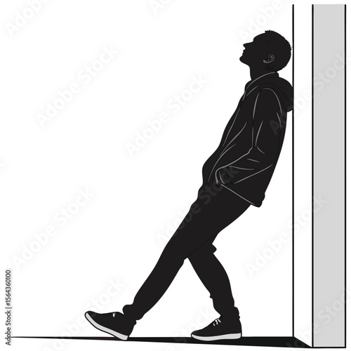 Silhouette of a Young Man Leaning Against a Wall: A Contemplative Pose