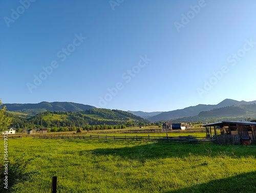 Wallpaper Mural Grassy field with a fence in the middle against the background of the hills Torontodigital.ca