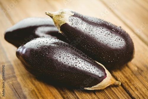 Wet eggplants on wooden floor