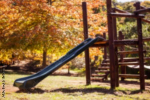 Wooden playground structure is featuring green slide and ladder in flat design under autumn trees