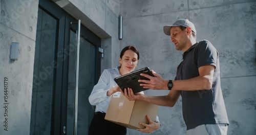 Postman Delivering Parcel Box for Recipient Working in Modern Office. Businesswoman Taking Package with Online Shopping Order, Signing POD on Tablet Computer. Delivery or Postal Service. Slow Motion.