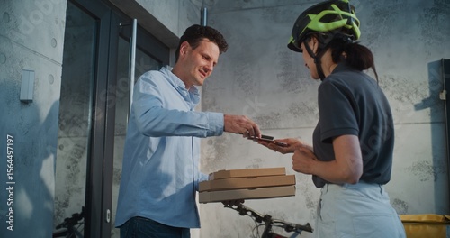 Woman Working in Pizza Delivery Service, Brining Restaurant Food for Client Working in Office Building. Businessman Taking Pizza in Cardboard Boxes, Paying for Order Contactless Using Smartphone.