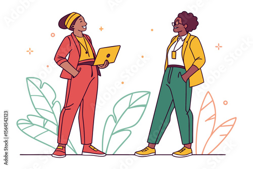 Two diverse women in stylish business casual attire collaborating and smiling while holding a laptop and standing near abstract foliage