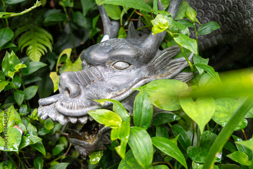 Obraz premium Bronze dragon fountain hidden in greenery on Enoshima Island, Japan