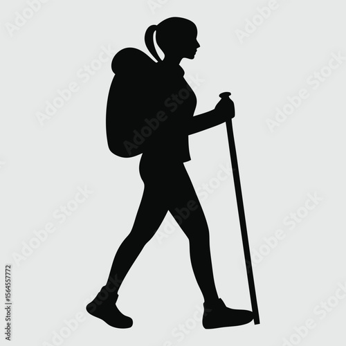 Silhouette of a woman hiking with a backpack and trekking pole