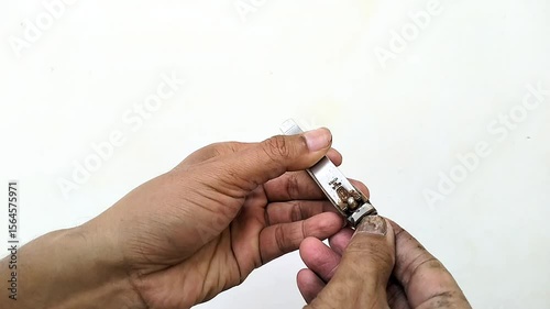 Close-up of a man’s hands using a metal nail clipper to trim fingernails
