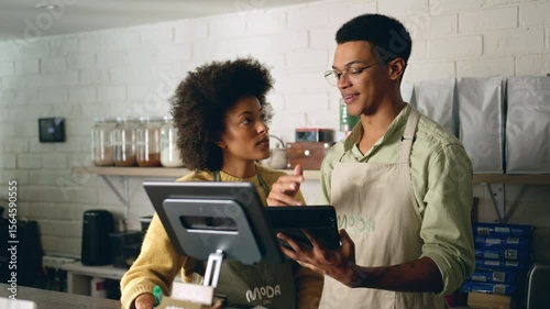 Two African American baristas checking the online orders on the tablet