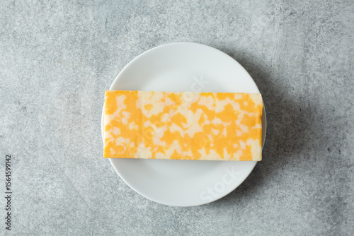 A top down view of a block of Colby Jack cheese, on a plate.