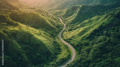 Aerial view of green mountains with a winding road