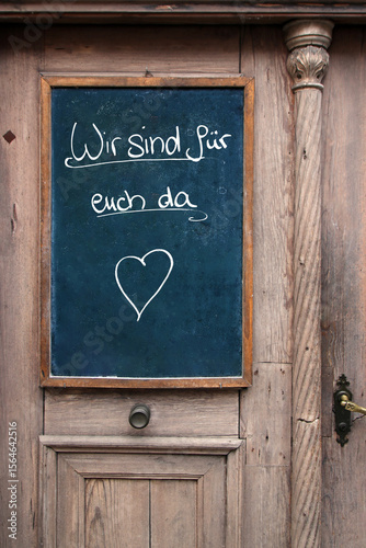 wir sind für euch da tafel an der eingangstür