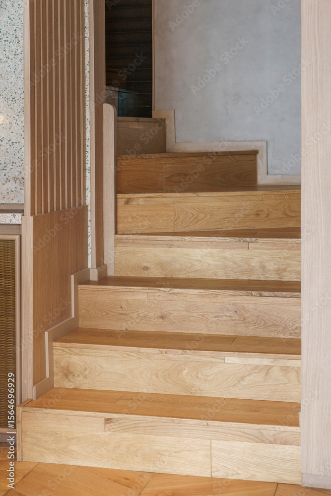 Modern light oak staircase with a minimalist architectural design. Detail shot of the clean lines of the wooden steps, risers, and joinery in a contemporary home interior. Modern light oak staircase with a minimalist architectural design. Detail shot of the clean lines of the wooden steps, risers, and joinery in a contemporary home interior.