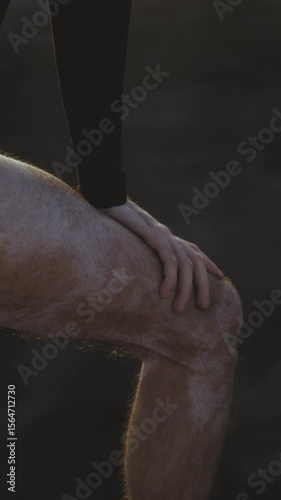 Close-Up of Man’s Foot and Hand Standing in the Sea

