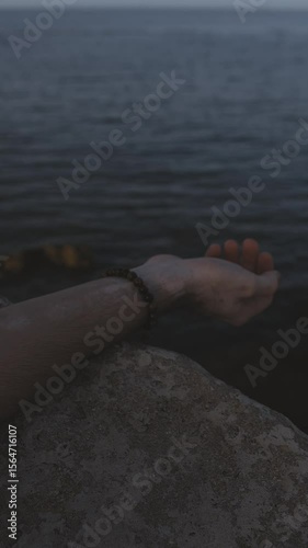 Close-Up of Man’s Hand Resting on Rocky Surface


