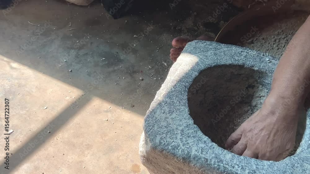jarak dekat, seorang pria yang sedang menumbuk, dengan lesung batu dan kayu tradisional