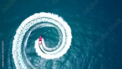 Aerial footage of a pink speedboat turning sharply in the deep blue ocean water