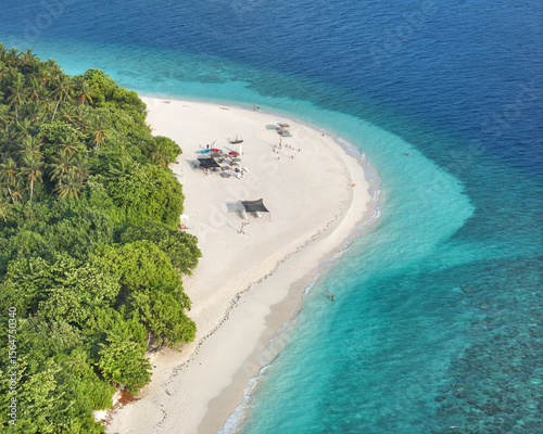 Aerial view of an island with a white sandy beach meeting the turquoise ocean, lush green vegetation, Kamadhoo, Baa Atoll, Maldives.