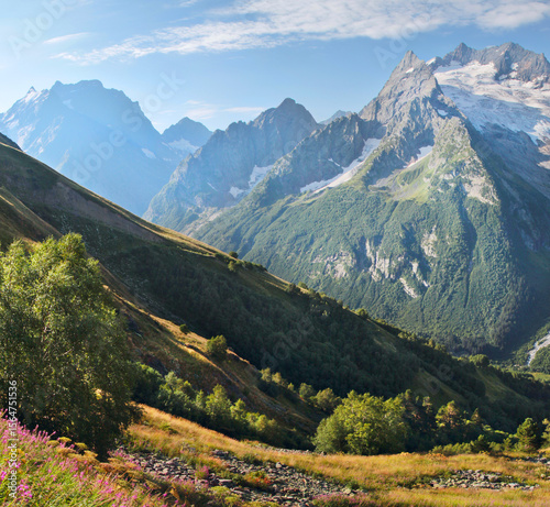 Mountain landscape, deep gorge, snow-capped rocky peaks, sunny day, Caucasus Mountains	