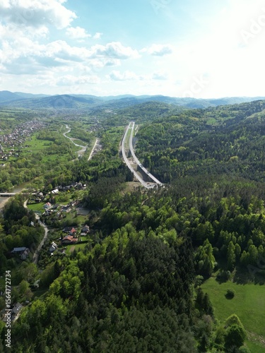 Fototapeta Naklejka Na Ścianę i Meble -  Budowa drogi ekspresowej S1 między Węgierską Górką a Milówką widziana z drona w wiosenny dzień. Construction of the S1 expressway between Węgierska Górka and Milówka captured by drone on a spring day 