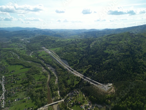 Fototapeta Naklejka Na Ścianę i Meble -  Budowa drogi ekspresowej S1 między Węgierską Górką a Milówką widziana z drona w wiosenny dzień. Construction of the S1 expressway between Węgierska Górka and Milówka captured by drone on a spring day 