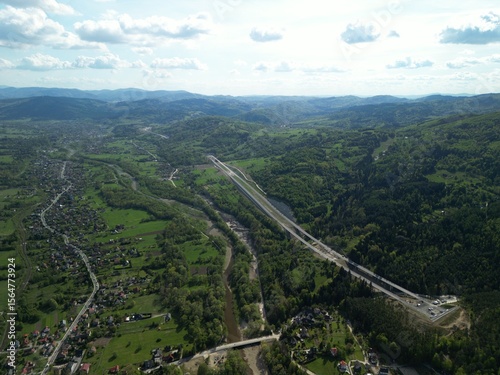 Fototapeta Naklejka Na Ścianę i Meble -  Budowa drogi ekspresowej S1 między Węgierską Górką a Milówką widziana z drona w wiosenny dzień. Construction of the S1 expressway between Węgierska Górka and Milówka captured by drone on a spring day 