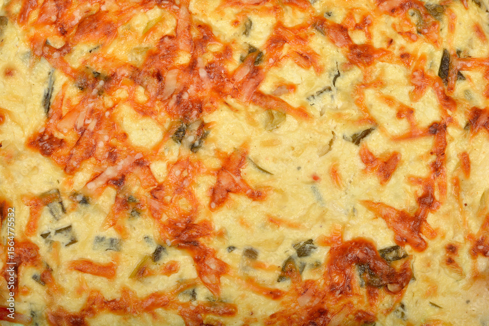 A close-up shot shows the golden-brown surface of a baked cheese and green onion pie A close-up shot shows the golden-brown surface of a baked cheese and green onion pie