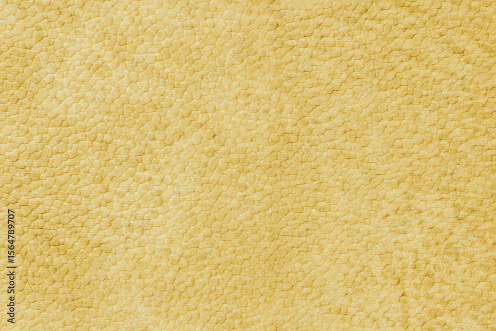 Fototapeta premium Detailed close up, macro of yellow synthetic suede leather texture, faux leather, leatherette. Background for design, fashion, upholstery material visuals. Natural grain structure, soft look.