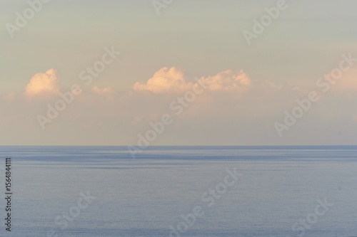 scenic sunrise or sunset above sea water with beautiful ocean vawes , nice golden evening clouds above horizon and awesome blue sky