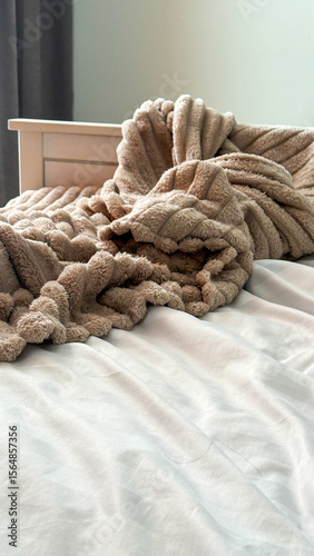 Fotografija Sumptuous beige throw cascades over minimalist bed, inviting cozy hygge moments