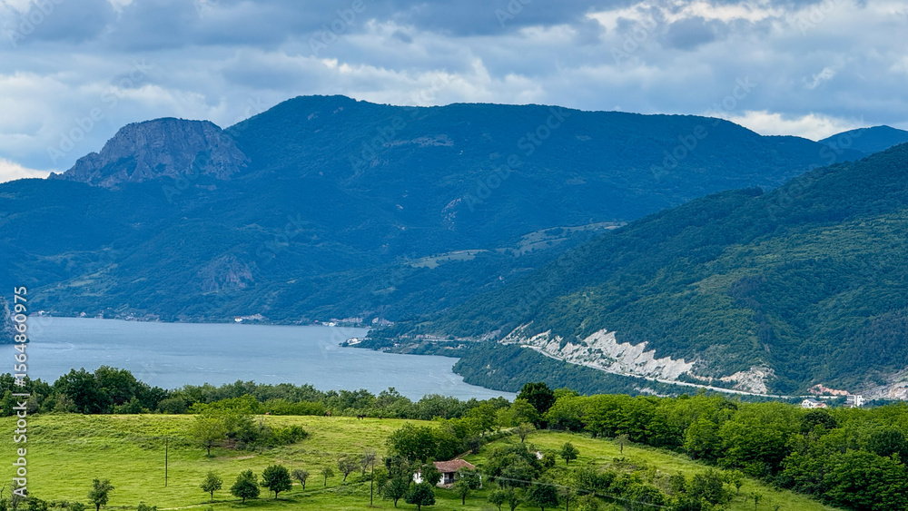 Obraz premium Mountain embrace surrounds serene azure lake, verdant tapestry stretching vast, Earth Day tranquility, solstice dawn whispers in nature's breath