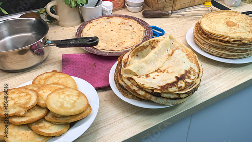 Pancakes stacked like golden treasures evoke Maslenitsa warmth, culinary pancake artistry, kitchen nostalgia, and Shrove Tuesday indulgence