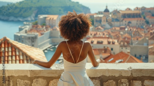 Young black woman looking at city skyline from a stone balcony  